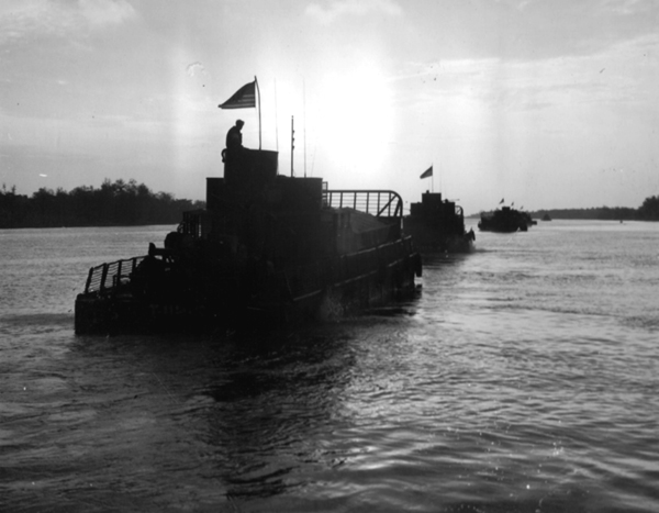 PICTURE - Armored Troop Carriers Move up the My Tho River in the Early Morning